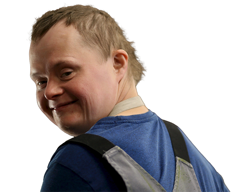 ein Junge mit Beeinträchtigung dreht sich mit dem Gesicht zur Kamera und lächelt